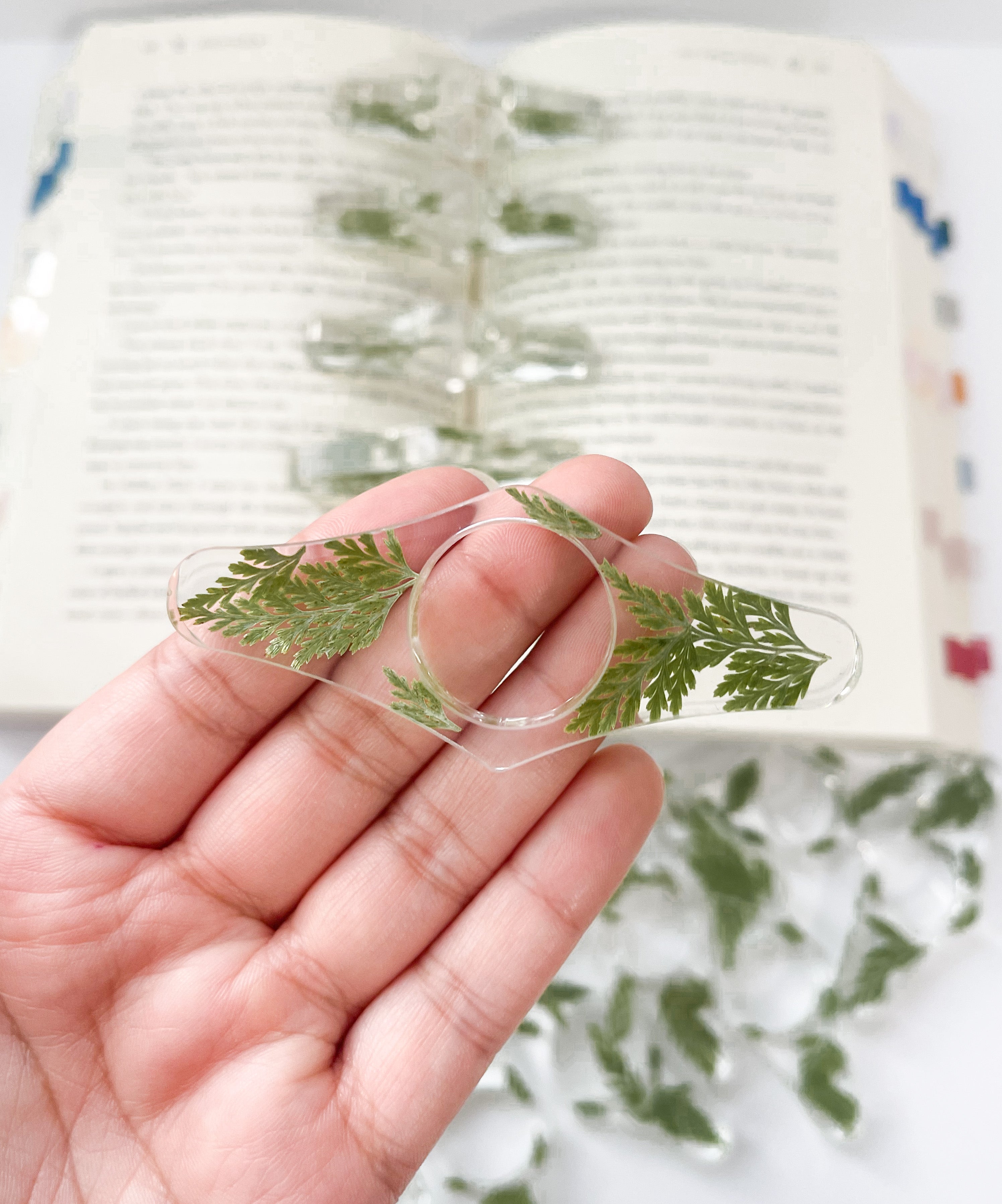 Book page holder spreader fern plant, front view, clear resin